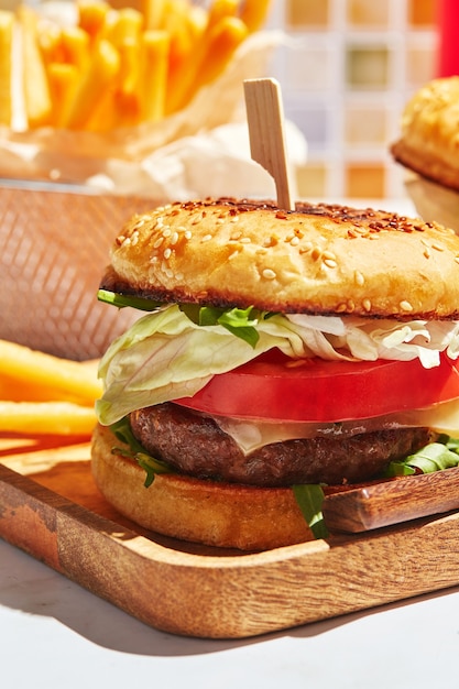 Delicious homemade burgers on wooden tray in bright sunlight burgers