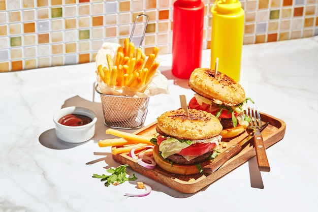Delicious homemade burgers on wooden tray in bright sunlight burgers