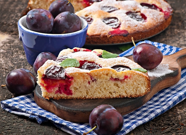 Delicious homemade cake with plums on a wooden table