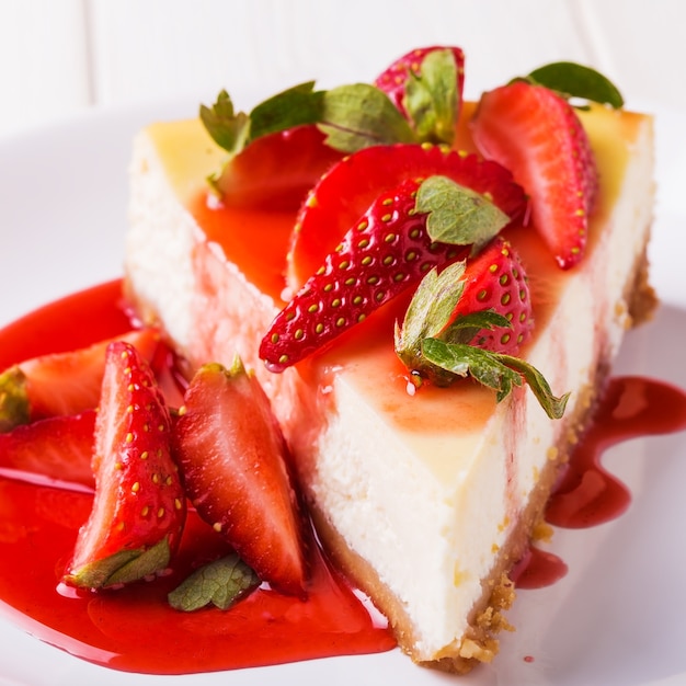 흰색 나무 테이블에 딸기와 맛있는 수 제 치즈 케이크.