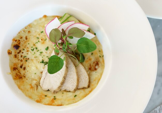 Deliziosi ravioli di pollo fatti in casa gratinati sul piatto bianco