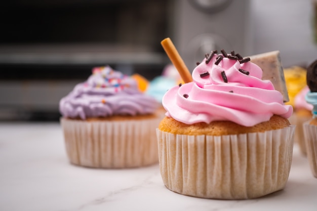 다채로운 크림과 사탕과 초콜릿 쿠키를 토핑한 맛있는 수제 컵케이크. 홈메이드 가을 휴가 디저트