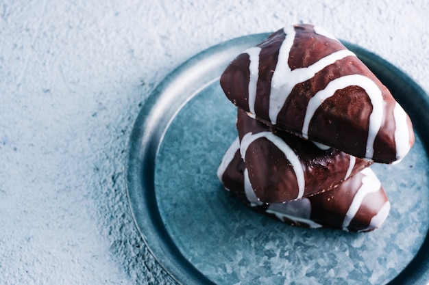 Delicious homemade dessert of black and white chocolate filled with cream. Triangle shaped dessert on wooden table