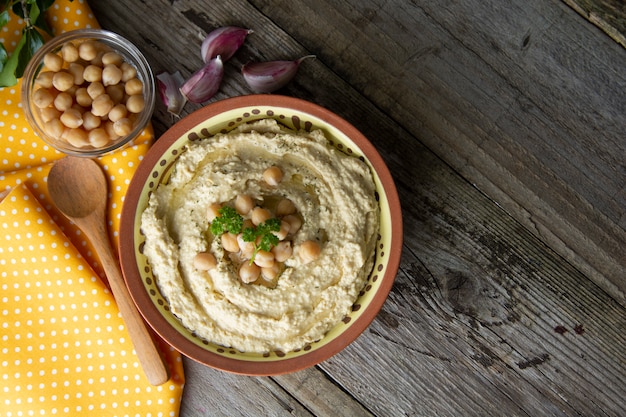 Delicious homemade hummus pasta with olive oil and chick-peas. Wooden table. Healthy food.