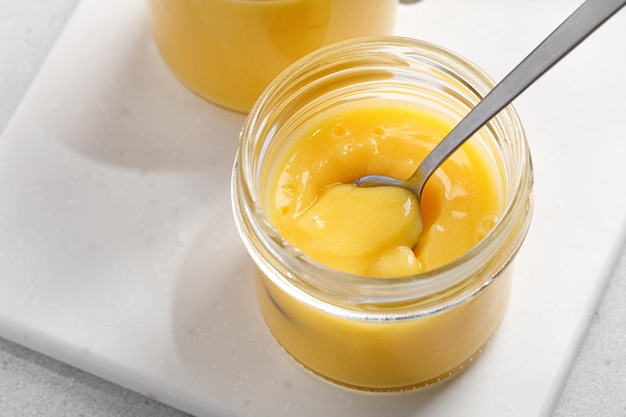 Delicious homemade lemon curd decorated with fresh fruit in a glass jars Lemon dessert