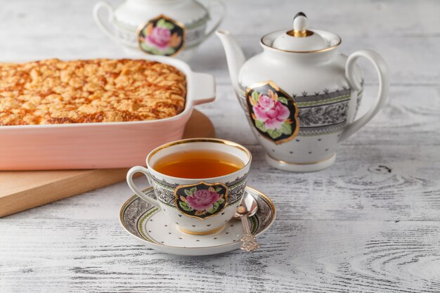 Delicious homemade lemon tart pie with green tea on rustic white table