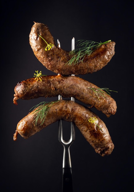 Delicious homemade meat sausages on a fork The idea of a delicious lunch for a hotel