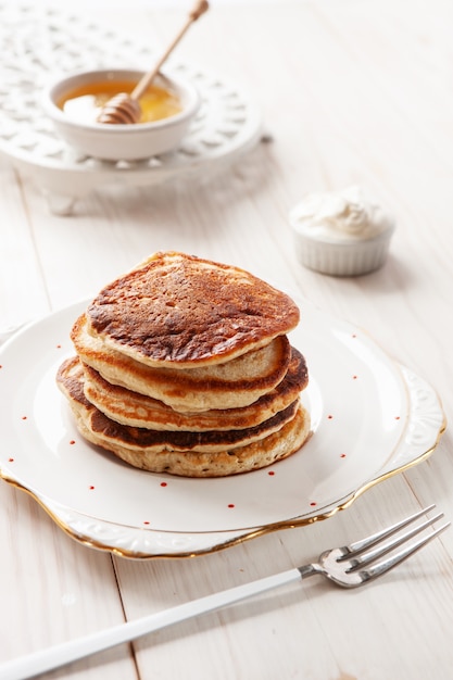 Delicious homemade pancakes with sour cream and honey