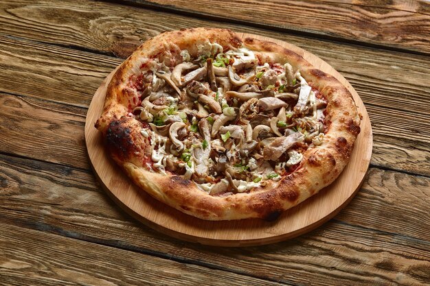 Delicious homemade pizza with mozzarella mushrooms beef and chicken Dark background selective focus