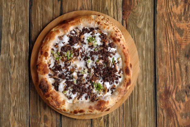 Delicious homemade pizza with mozzarella mushrooms beef and chicken Wooden background selective focus