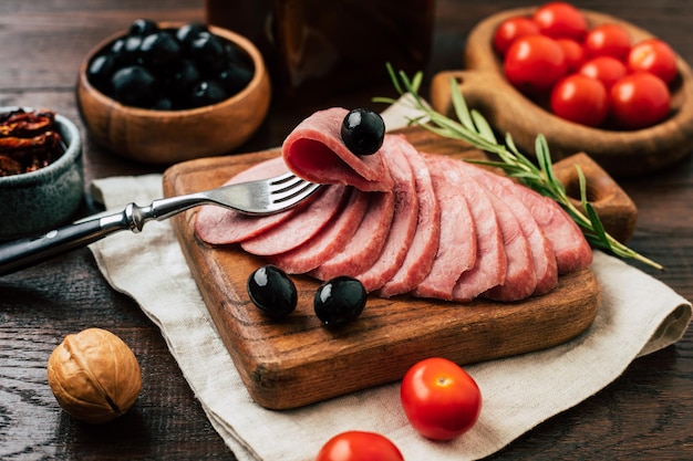 Photo delicious homemade sausage cut into pieces on a wooden board