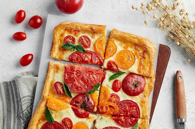 Delicious homemade square pizza with vegetables on white.