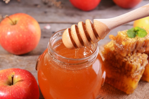 Delicious honey with apple on table closeup