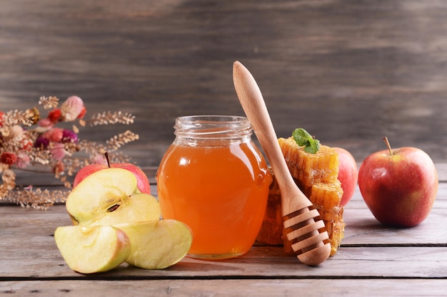 delicious honey with apple on table on wooden background