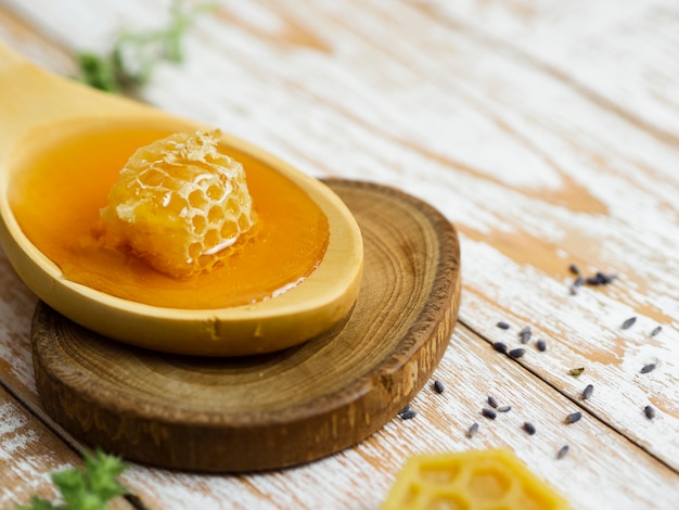 Photo delicious honeycomb on wooden spoon