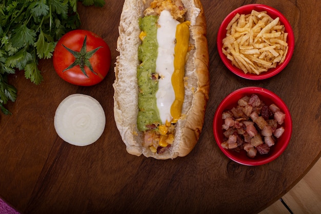 Delizioso hot dog con ingredienti e su sfondo colorato o in legno