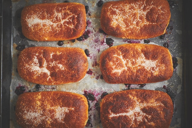 Foto delicious hot homemade buns gevuld met bosbessen op een bakplateau flat lay top view