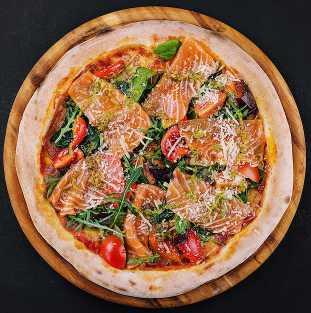 Delicious hot pizza with salmon cheese tomatoes and aragula