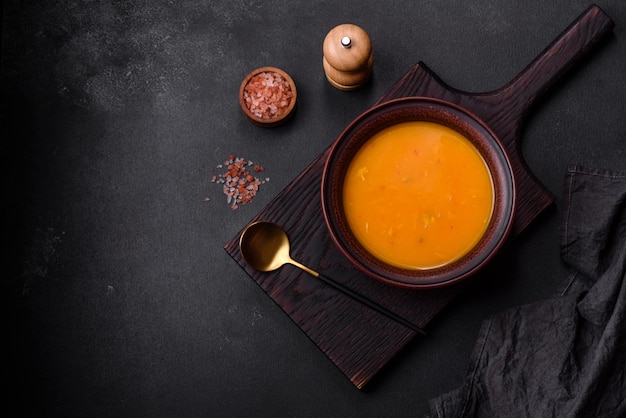 Фото Вкусный горячий суп-пюре из тыквы и моркови со специями и зеленью