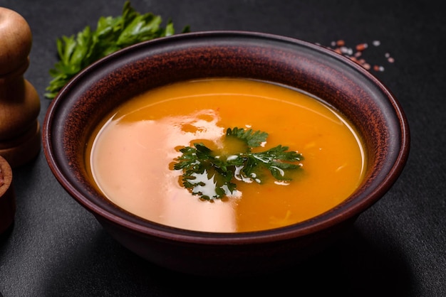 Delicious hot pumpkin and carrot soup puree with spices and herbs