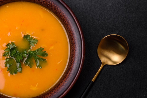 Delicious hot pumpkin and carrot soup puree with spices and herbs