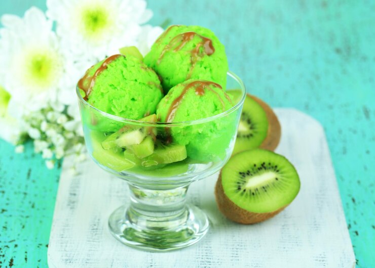 Фотография вкусное мороженое на стеклянной вазе на деревянном столе крупным планом