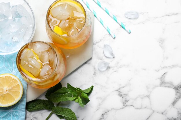 Delicious iced tea on white marble table flat lay Space for text