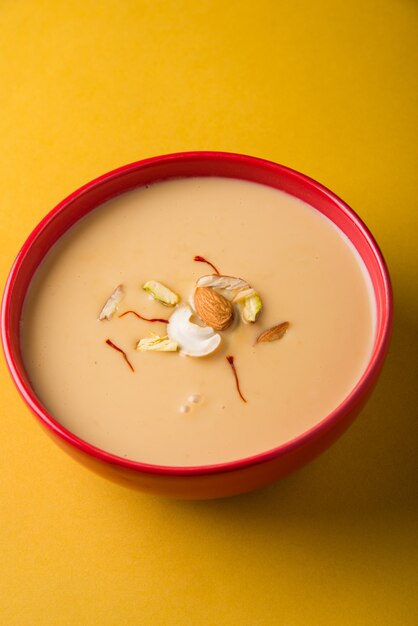 Delicious Indian sweet Rabdi or Rabri with dry fruits toppings. Popular festival food tests great with Jalebi/Jilbi. Served in a bowl over colourful or wooden table top. Selective focus