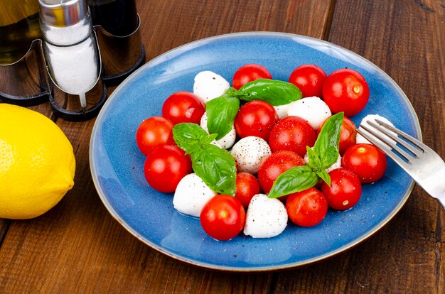 Delicious Italian caprese salad with basil, mozzarella and cherry tomatoes. Studio Photo.