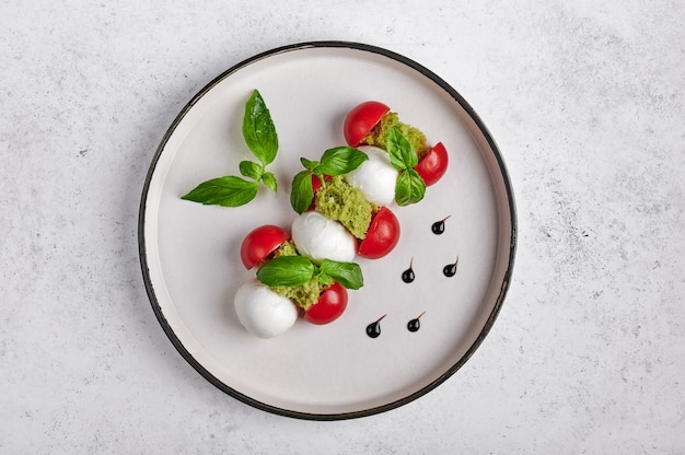 Delicious italian caprese salad with ripe tomatoes, fresh garden basil and mozzarella cheese