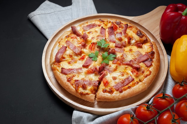 Delicious Italian pizza sliced ham, bacon and cheese with food ingredients on old kitchen 