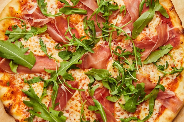 Delicious Italian Pizza with Parma ham and arugula, mozzarella cheese