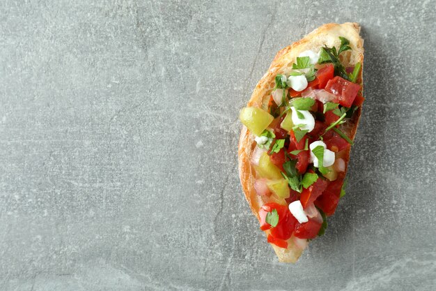 Delicious italian snack bruschetta on gray textured background