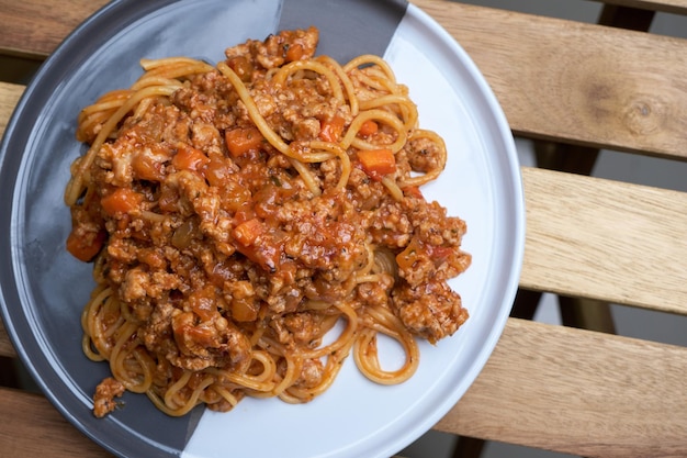 Delicious Italian spaghetti bolognese served on plate in wooden table