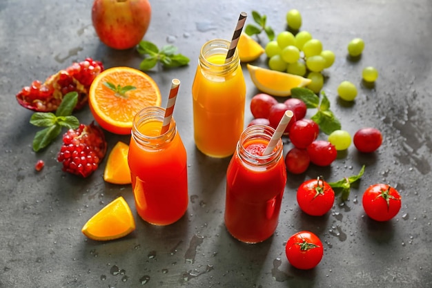 Delicious juices in bottles and fruits on table