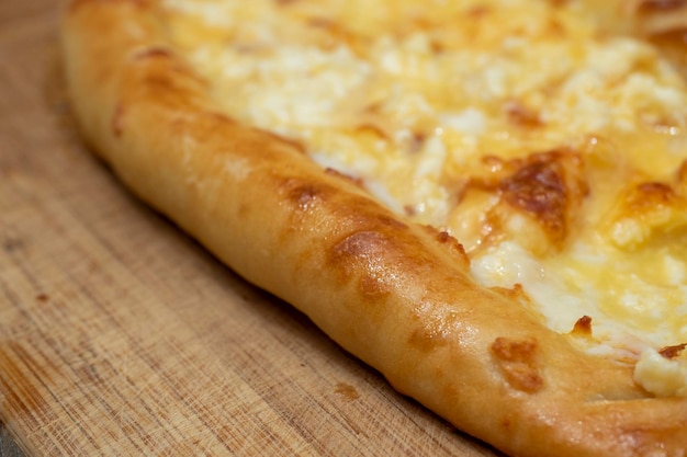 Delicious juicy Ajarian khachapuri close-up. Georgian dish made of dough and cheese