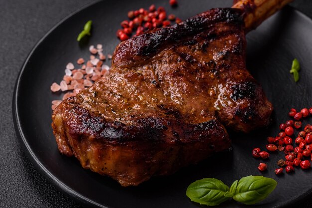 Delicious juicy beef steak on the bone tomahawk with salt spices and herbs