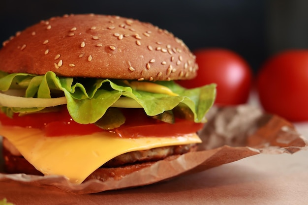 Delicious juicy burger with cutlet and fresh ingredients Fast food on a dark background closeup