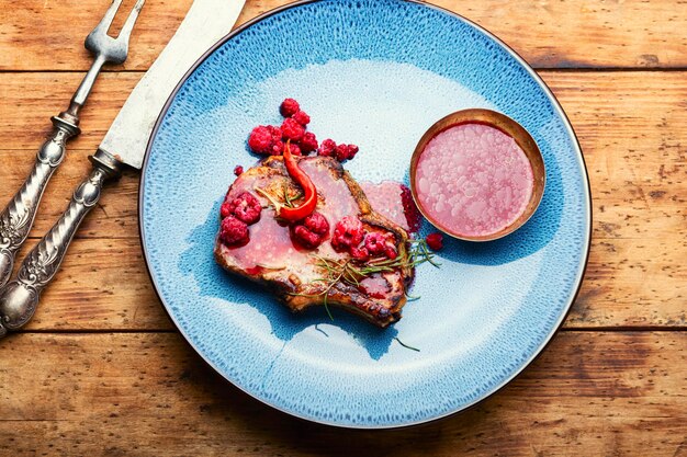 Delicious juicy fried pork with raspberry sauce