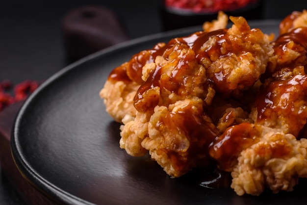 Delicious juicy grilled chicken meat bites with salt spices and herbs on a dark concrete background