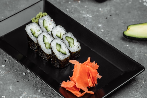 Вкусные, сочные и аппетитные маки с огурцом. Суши на сером фоне.