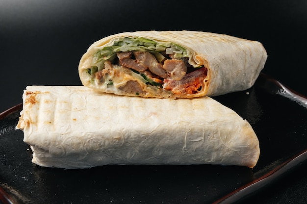 Delicious Juicy shawarma on a black surface