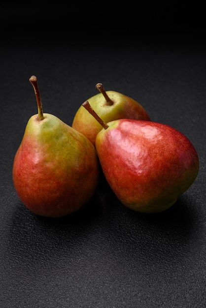 Delicious juicy sweet green pear with red side on dark textured concrete background