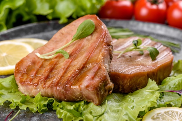 Foto deliziosa bistecca di tonno succosa alla griglia con spezie ed erbe aromatiche e fette di limone