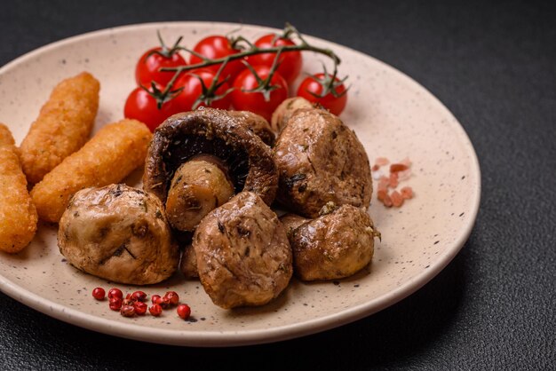 Delicious juicy whole champignons baked on the grill with salt and spices on a ceramic plate on a dark concrete background