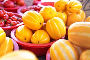 Фото Вкусная корейская полосатая желтая дыня с фруктами в красной пластиковой корзине на традиционном рынке днем в сеуле, южная корея, концепция сбора урожая крупным планом