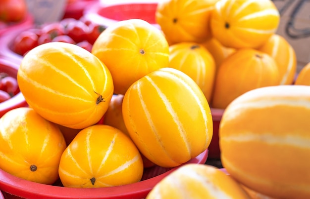 Delicious korean stripe yellow melon fruit food in red plastic basket at tradition market afternoon seoul south korea harvest concept close up