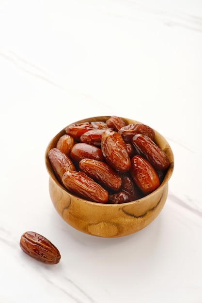 Delicious Kurma Tunisia Sweet Dried Dates palm fruits on wooden bowl Selected focus