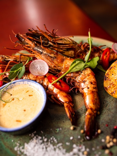 Delicious langoustine shrimps n restaurant on a wooden table, no people are visible. Tasty seafood with wine in cafemenu.