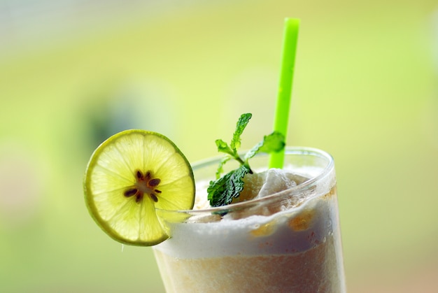 Delicious lemon juice in glass and limes.